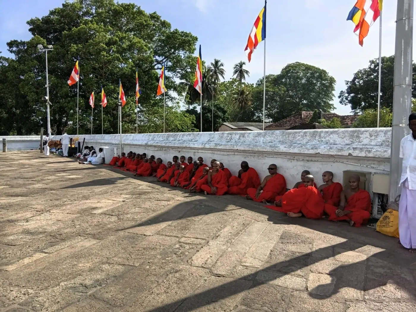 A long line of monks seated at a temple ceremony
