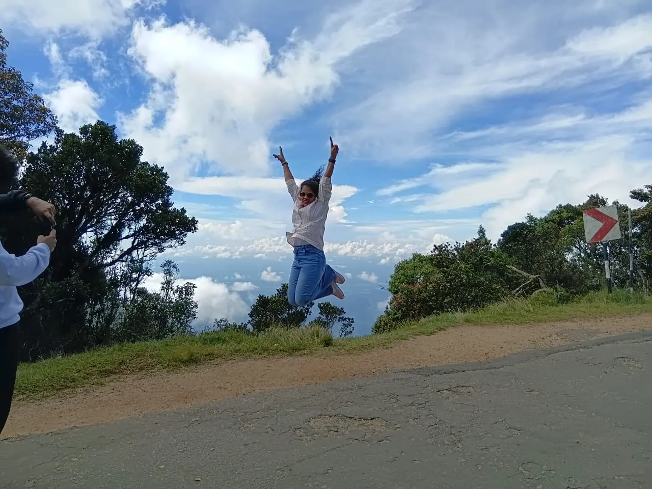 A guest jumping on a hilltop road high above the plains