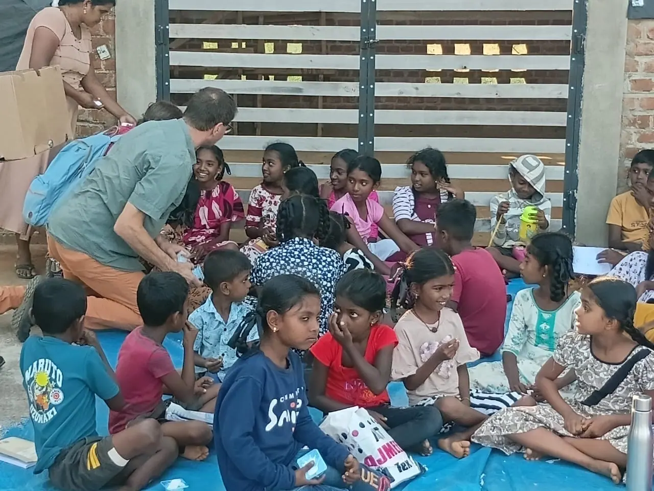 Village children reading the books brought by visiting guests
