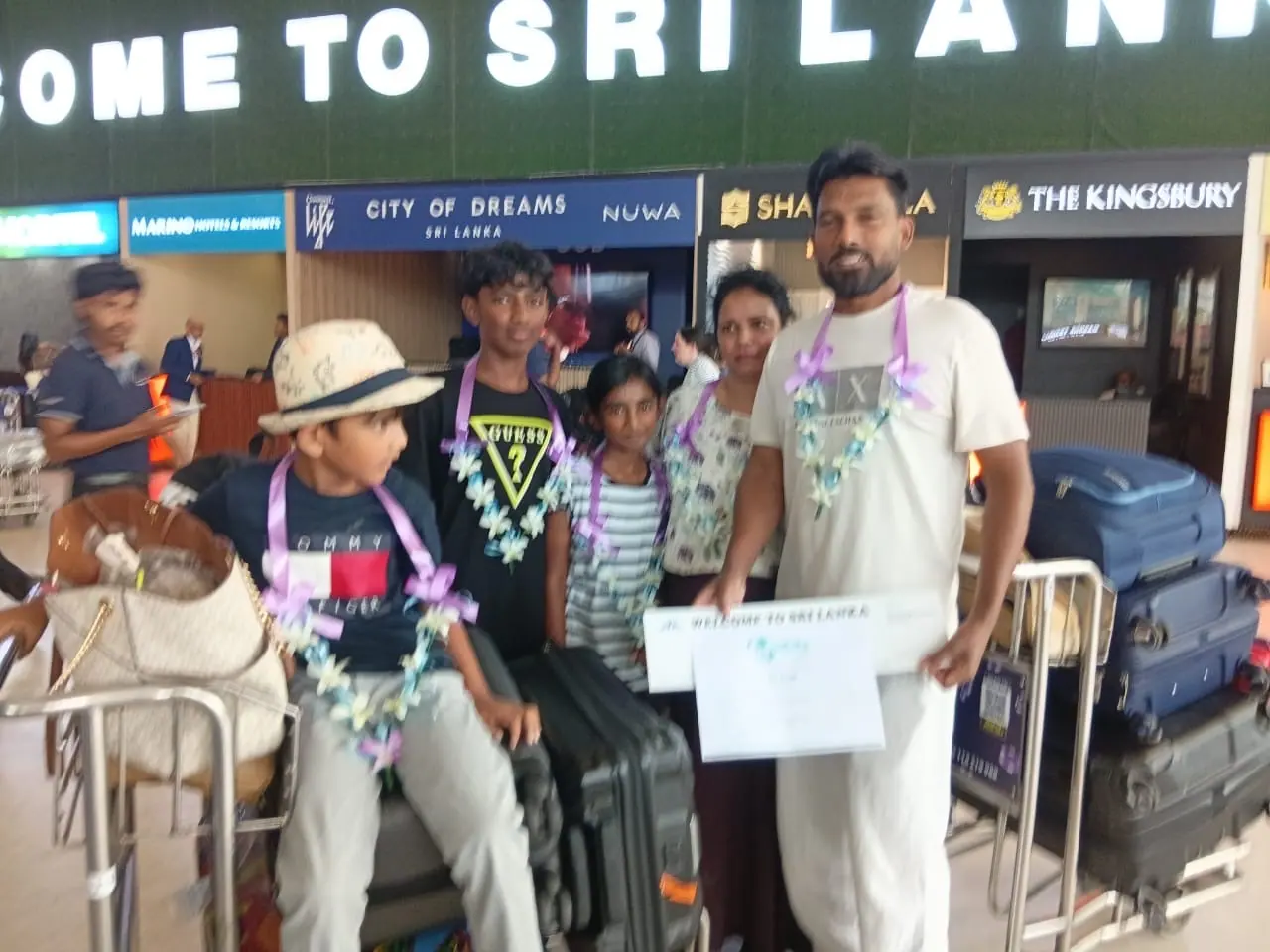 A family welcomed at Bandaranaike International Airport with flower garlands