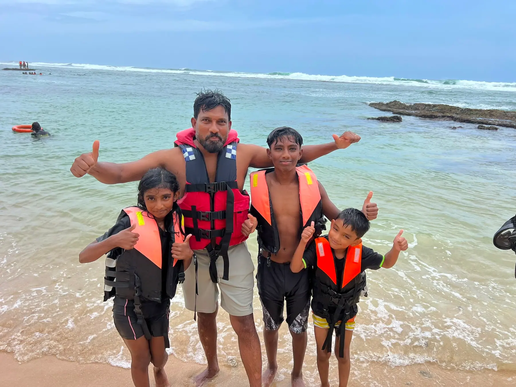 A father and children on the beach ready for water sports