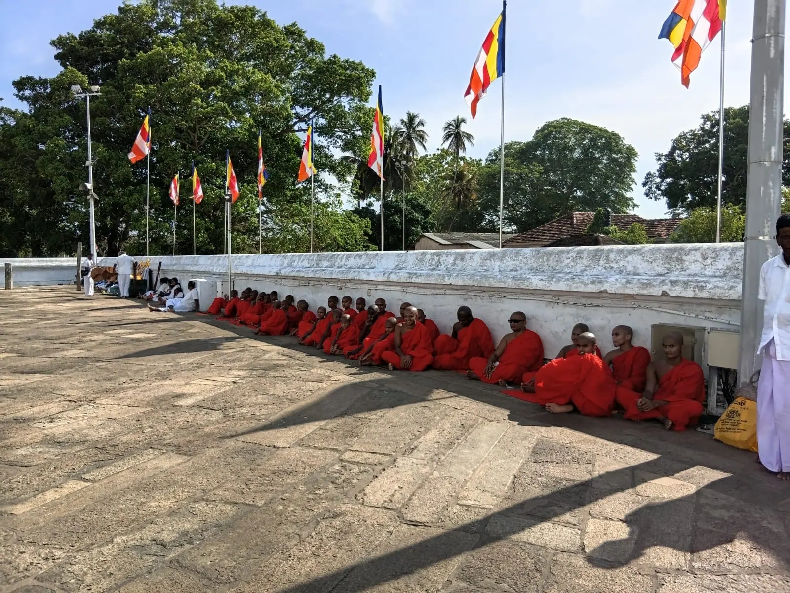 A long line of monks seated at a temple ceremony