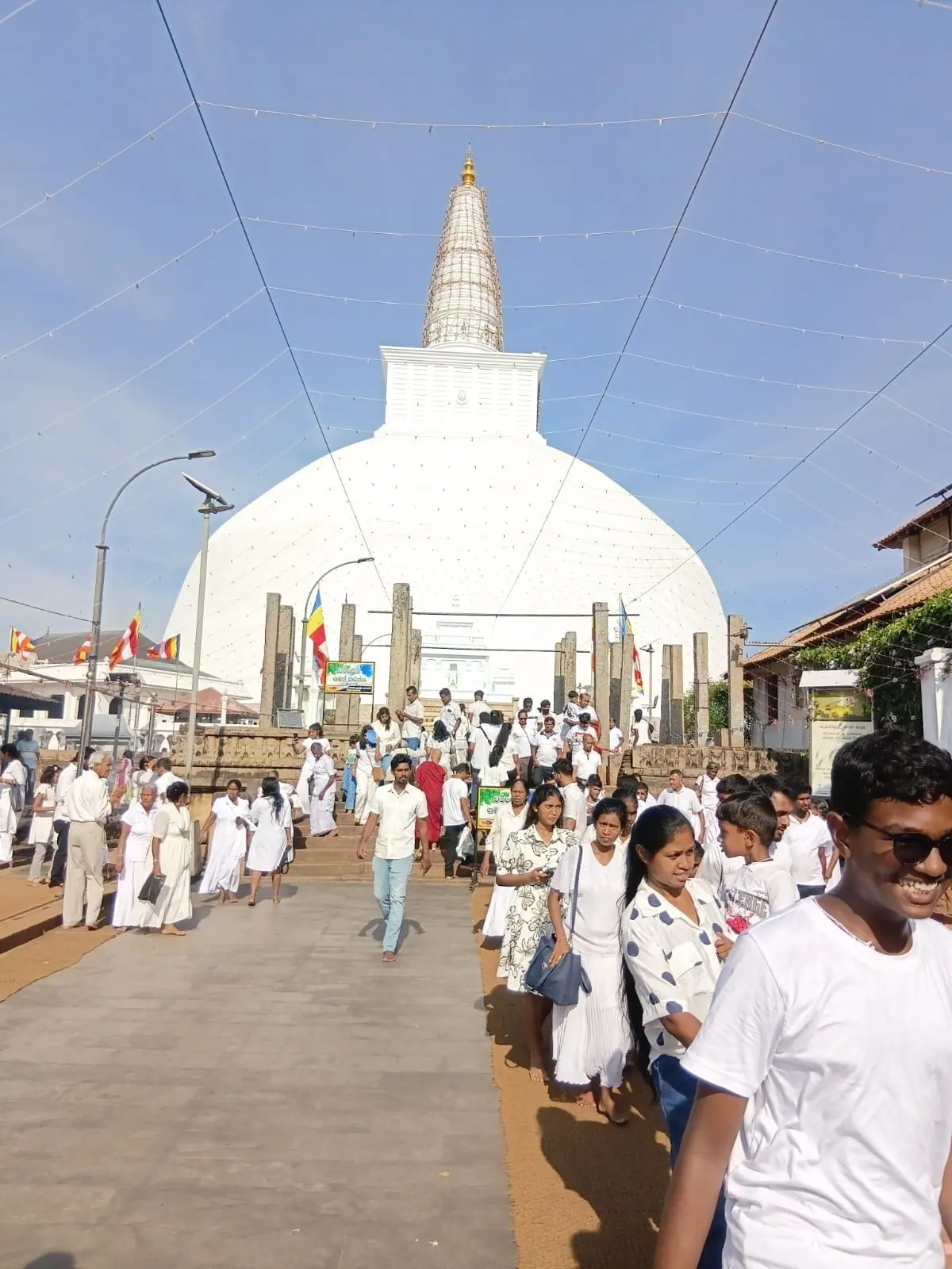 The white Ruwanwelisaya stupa in Anuradhapura crowded with pilgrims