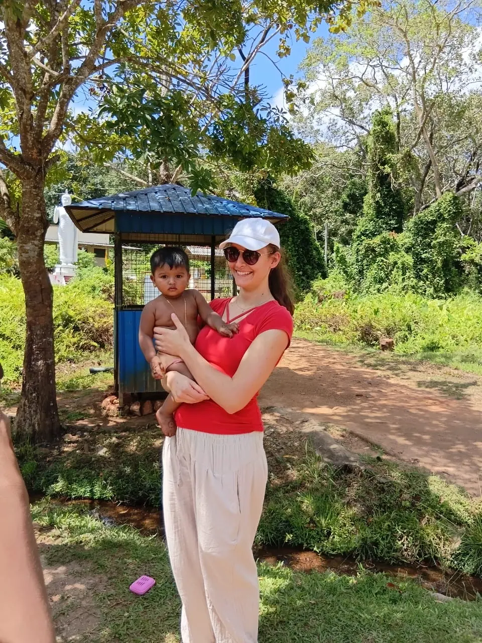 A guest holding a village child near the Sigiriya foothills