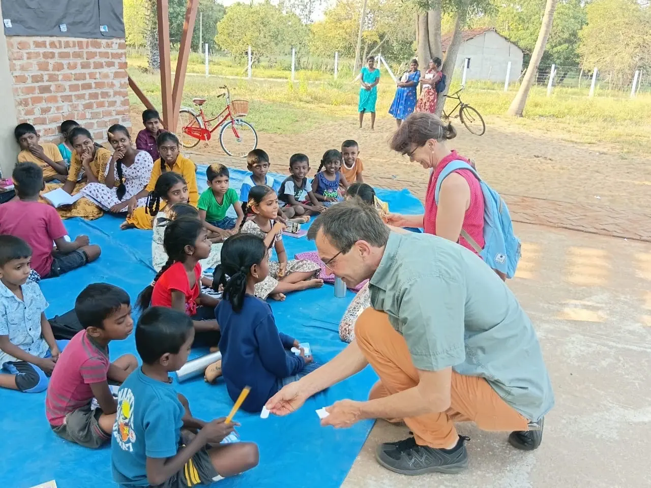 Guests giving out school books to village children